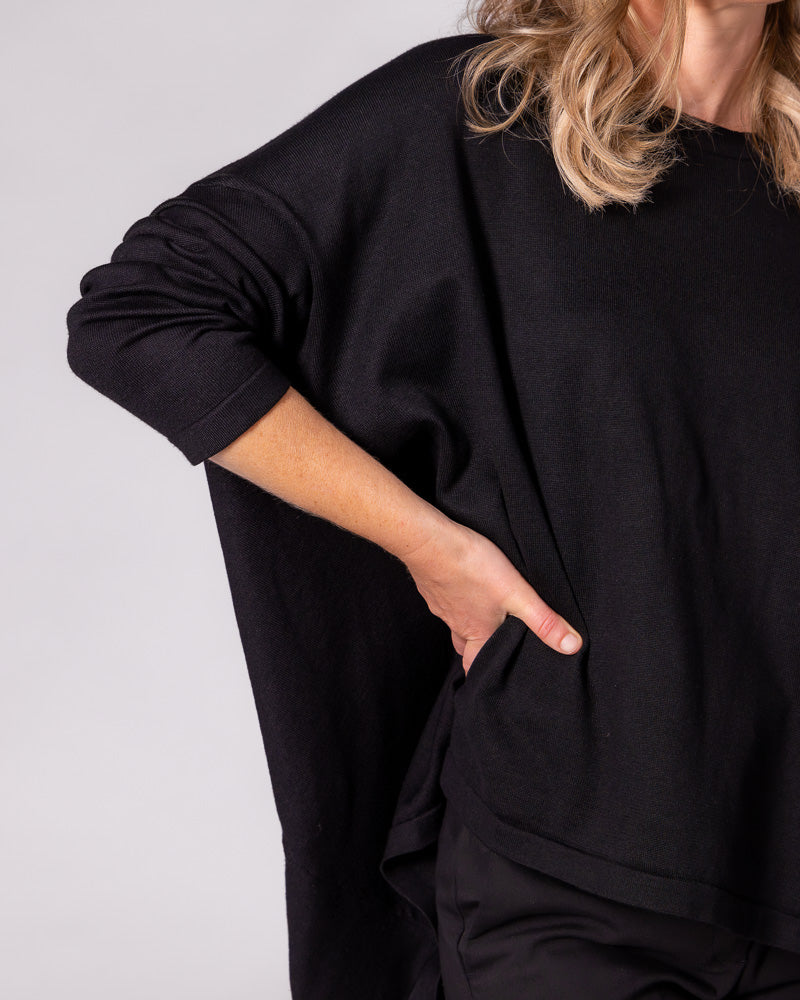 Black oversized cotton-blend jumper featuring a draped body, drop shoulder, fitted sleeve, and high-low hem.