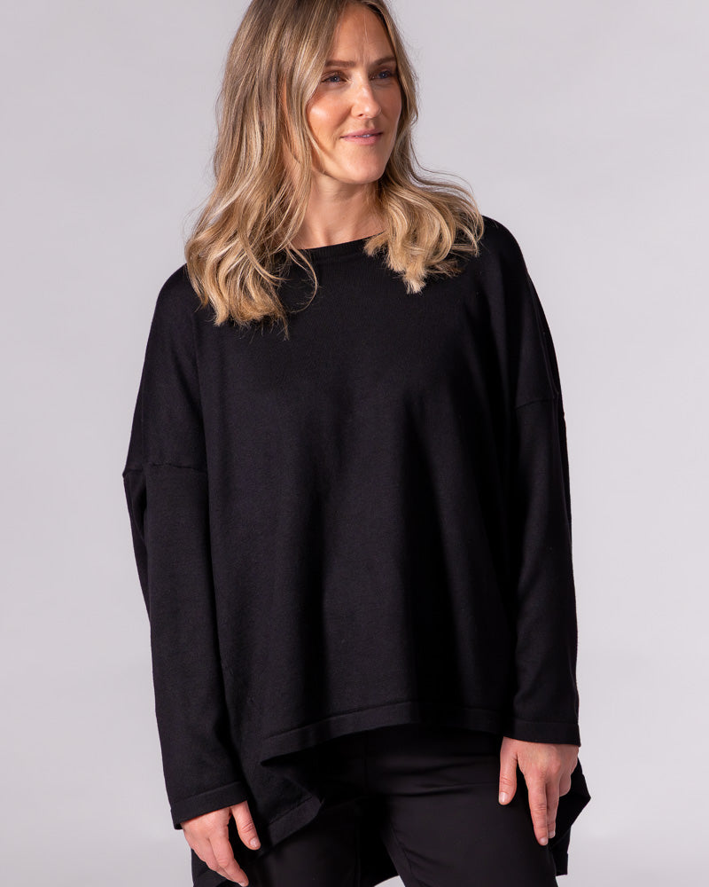 Black oversized cotton-blend knit jumper with a classic crew neckline, drop shoulders, and a draped high-low hem.