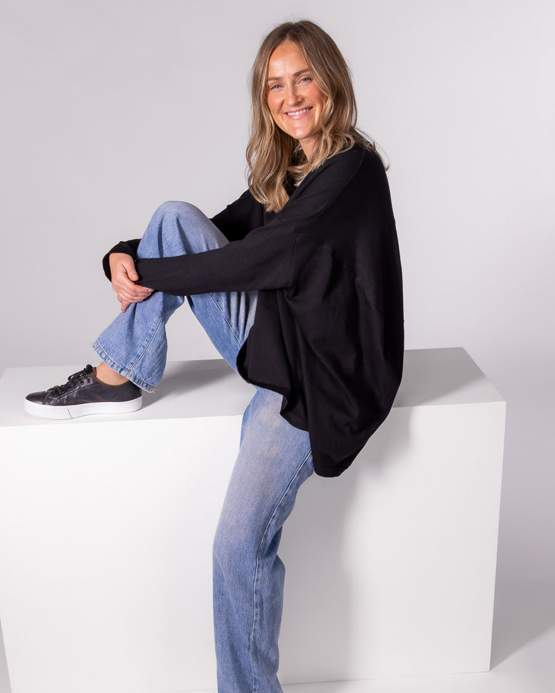 Oversized black cotton-blend knit jumper featuring long fitted sleeves and a softly draped high-low hem.