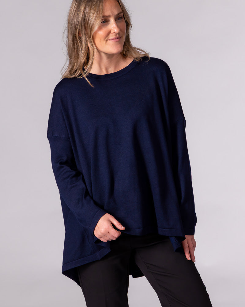 Oversized navy cotton-blend jumper featuring a crew neckline, long fitted sleeves, and a draped high-low hem.