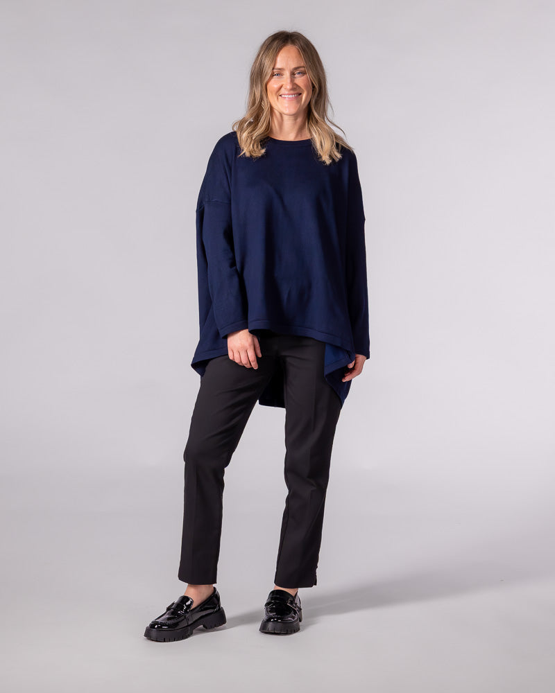 Navy cotton-blend knit jumper featuring a crew neckline, dropped shoulders, an oversized fit, and a draped high-low hem.