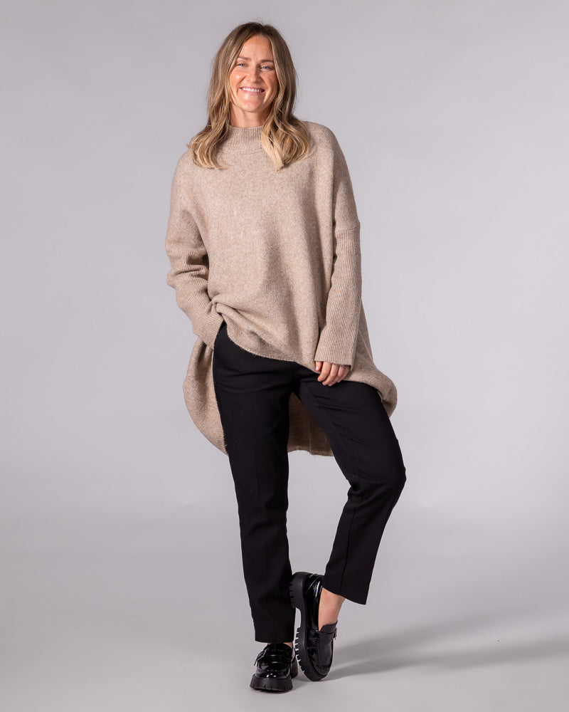 Oversized beige brushed knit jumper with a ribbed funnel neck, drop shoulders, ribbed sleeves and a high-low hemline.