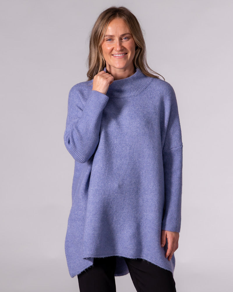 Oversized blue brushed knit jumper featuring a ribbed funnel neck, relaxed drop shoulders and long ribbed sleeves.