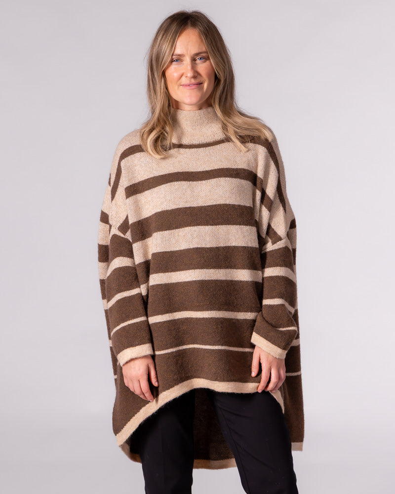 Oversized brown striped brushed knit jumper with a funnel neck, dropped shoulders, and a striking high-low hemline.