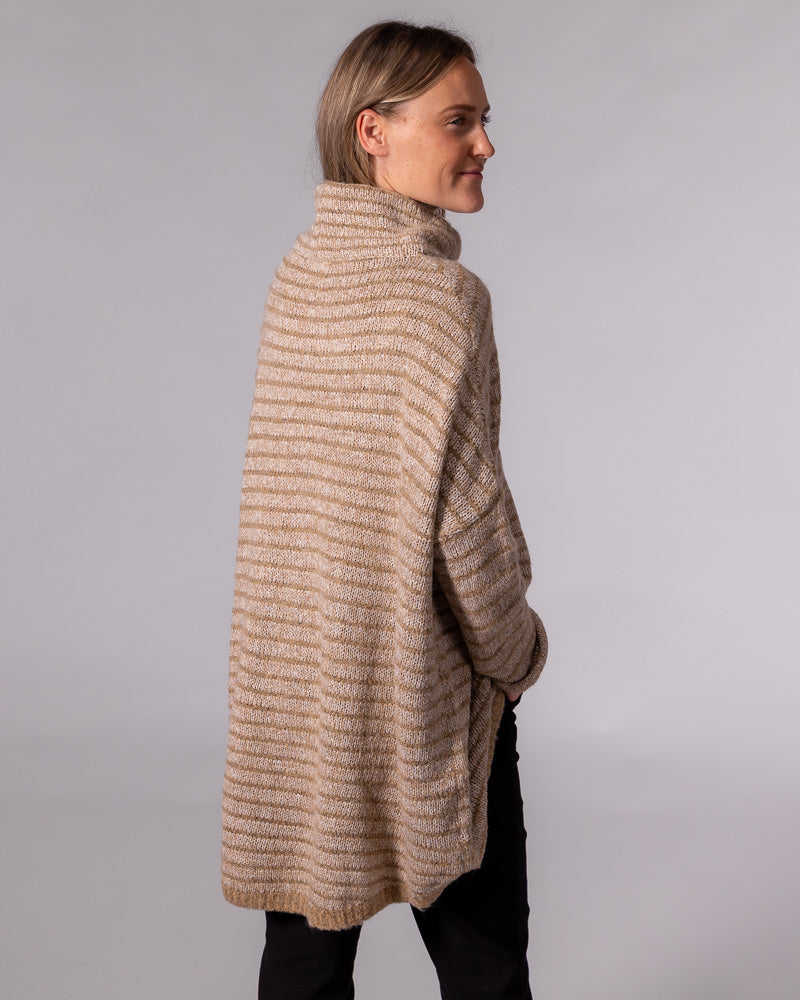 Oversized beige and mocha striped knit jumper displaying a funnel neck, dropped shoulders and a long scooped back hem.
