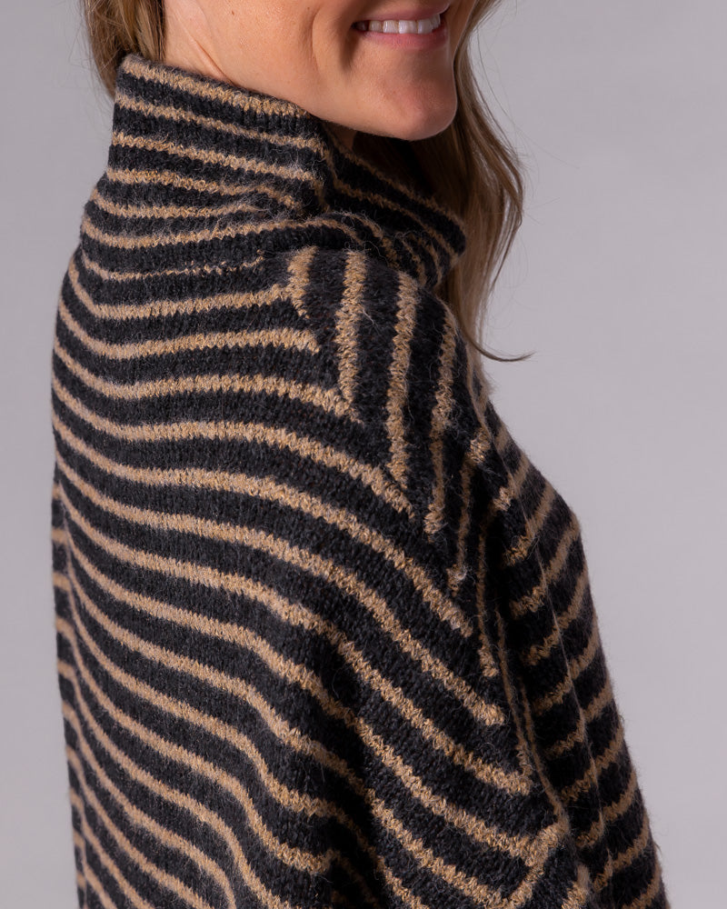 Funnel neck and drop shoulder details on a black and mocha striped brushed knit jumper.