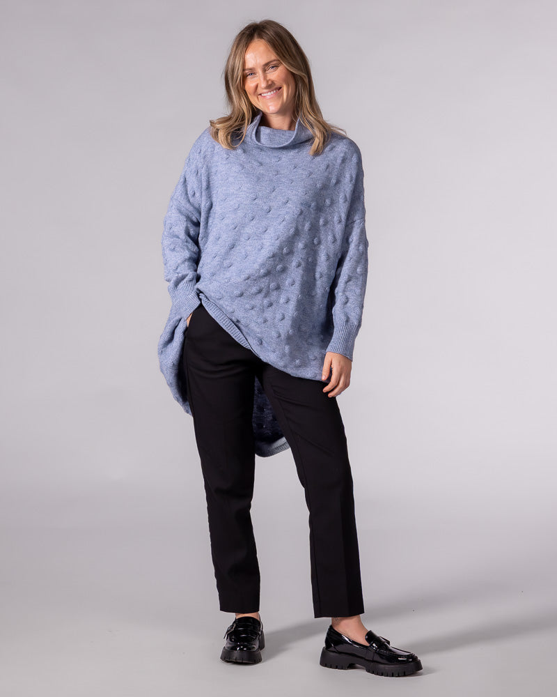 Light blue oversized knit jumper featuring a textured bubble pattern, slouchy funnel neck, and a high-low scooped hem.