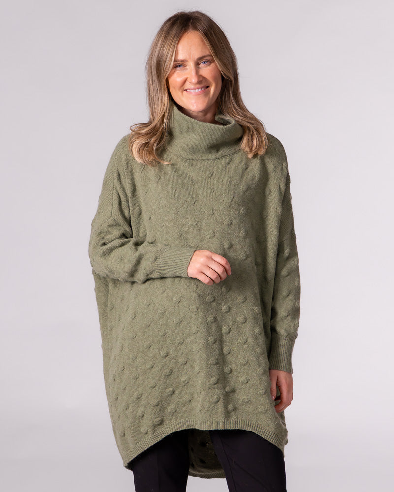 Oversized olive bubble knit jumper featuring a funnel neck, drop shoulders, ribbed cuffs and a scooped high-low hem.
