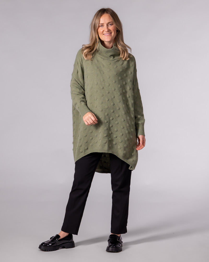 Oversized olive bubble knit jumper featuring a relaxed funnel neck, dropped shoulders, and a scooped high-low hem.