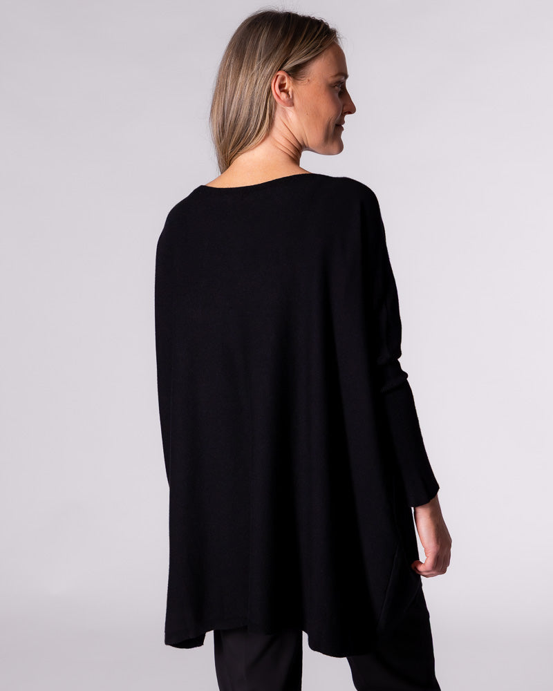 Back view of the Karma Kameleon black Willow knit jumper highlighting the drape back hemline and loose silhouette.