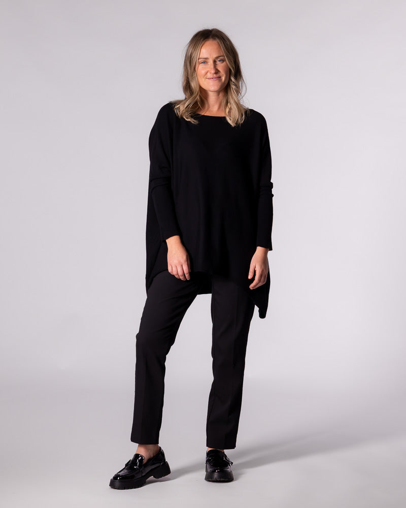 Full-length styling of the Karma Kameleon jumper paired with tailored pants and chunky loafers for a stylish look.