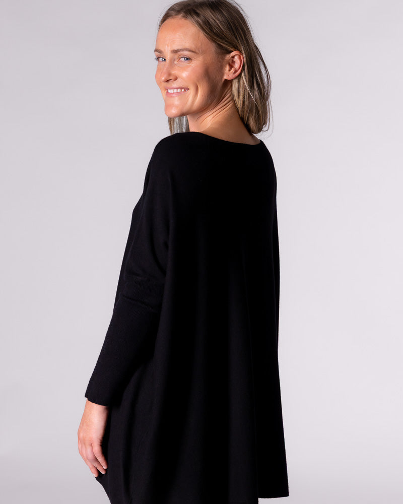 Side profile demonstrating the sweeping movement and relaxed flow of the knit top as it drapes effortlessly.