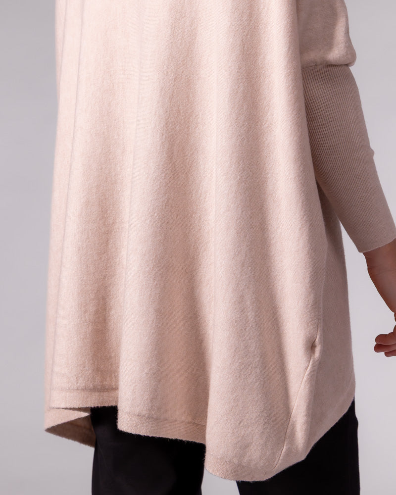 Blush cotton jumper highlighting the oversized draped back, curved hi-low hem, and fitted ribbed sleeve.