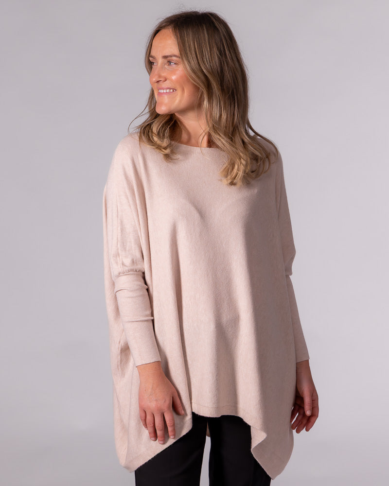 Oversized blush cotton knit jumper featuring a wide boat neckline, draped hem, and fitted ribbed lower sleeves.
