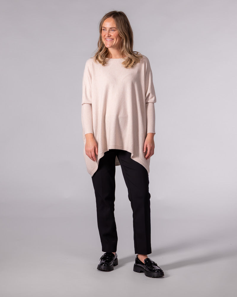 Blush oversized cotton knit jumper with a wide boat neckline, drop shoulders, fitted sleeves, and a draped hi-low hem.
