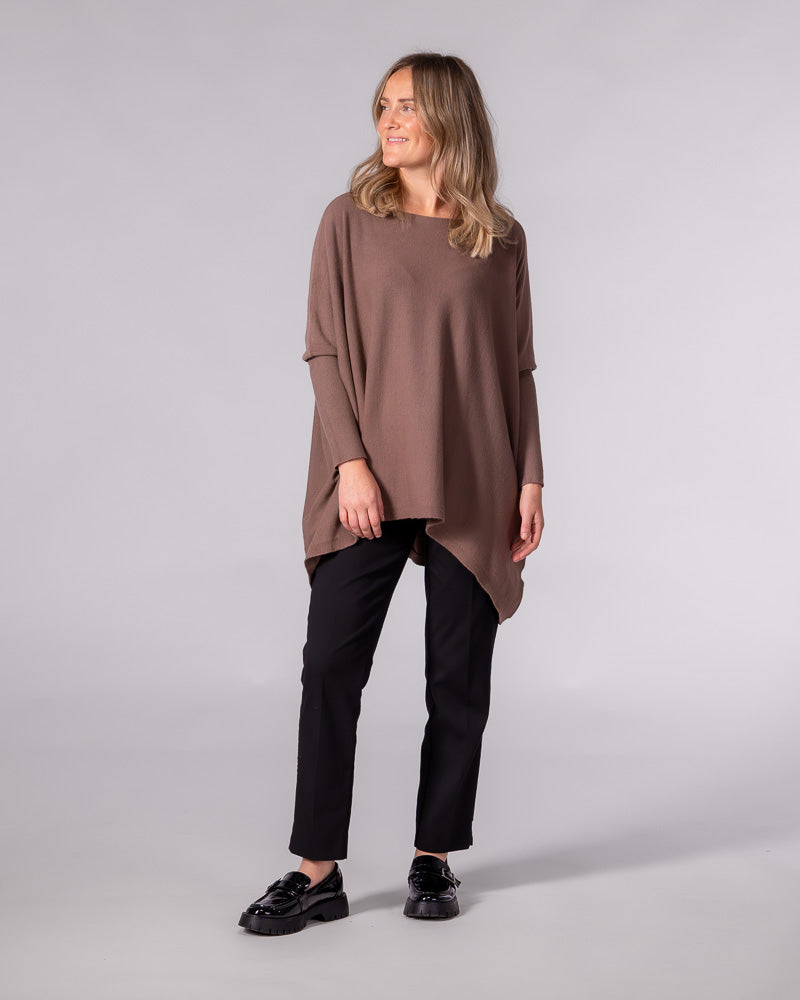 Oversized brown cotton knit jumper featuring a wide boat neckline, drop shoulders, fitted sleeves, and a hi-low hem.