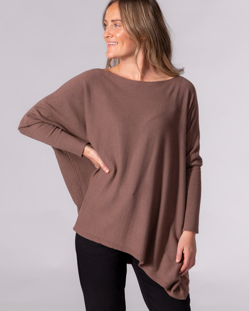 Brown cotton knit jumper featuring an oversized drape, wide boat neckline, and drop shoulders with fitted ribbed sleeves.