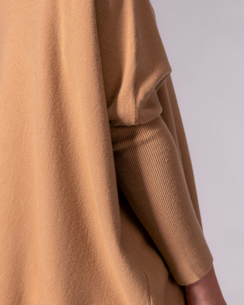 Camel cotton knit jumper highlighting the draped oversized body and the contrasting fitted ribbed lower sleeve.