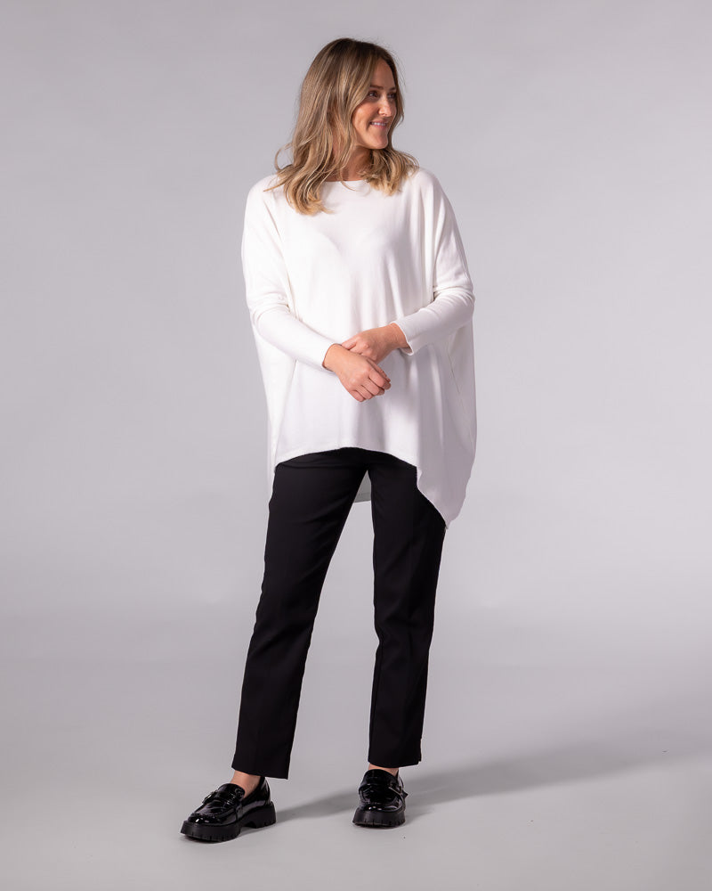 Oversized cream cotton knit jumper with a wide boat neckline, drop shoulders, fitted sleeves, and a hi-low hem.
