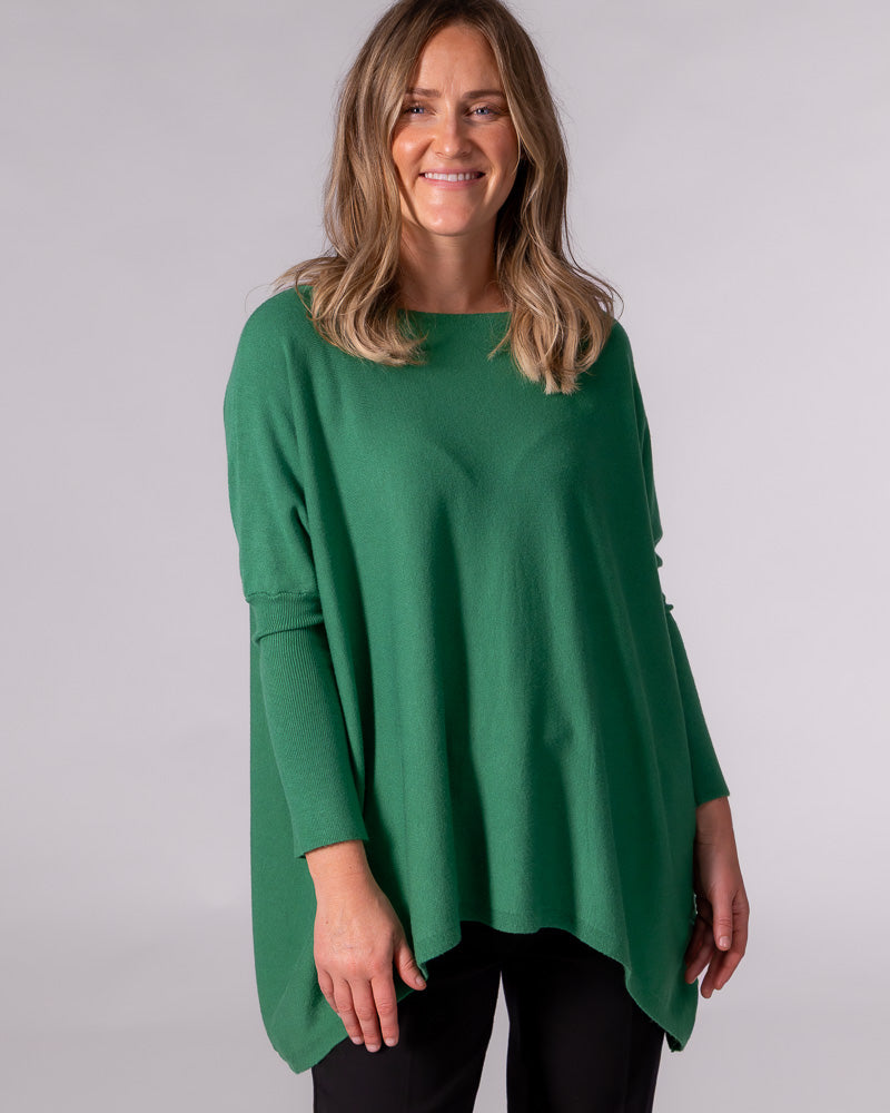 Oversized green cotton jumper featuring a wide boat neckline, drop shoulders, fitted sleeves, and a draped hi-low hem.