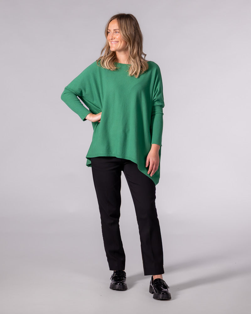 Oversized green cotton knit jumper featuring a wide boat neckline, fitted sleeves, and a draped hi-low hemline.