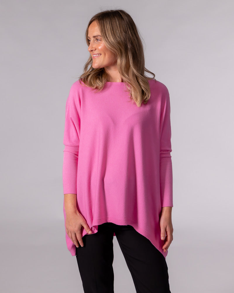 Hot pink oversized cotton jumper featuring a wide boat neckline, drop shoulders, and contrasting fitted sleeves.