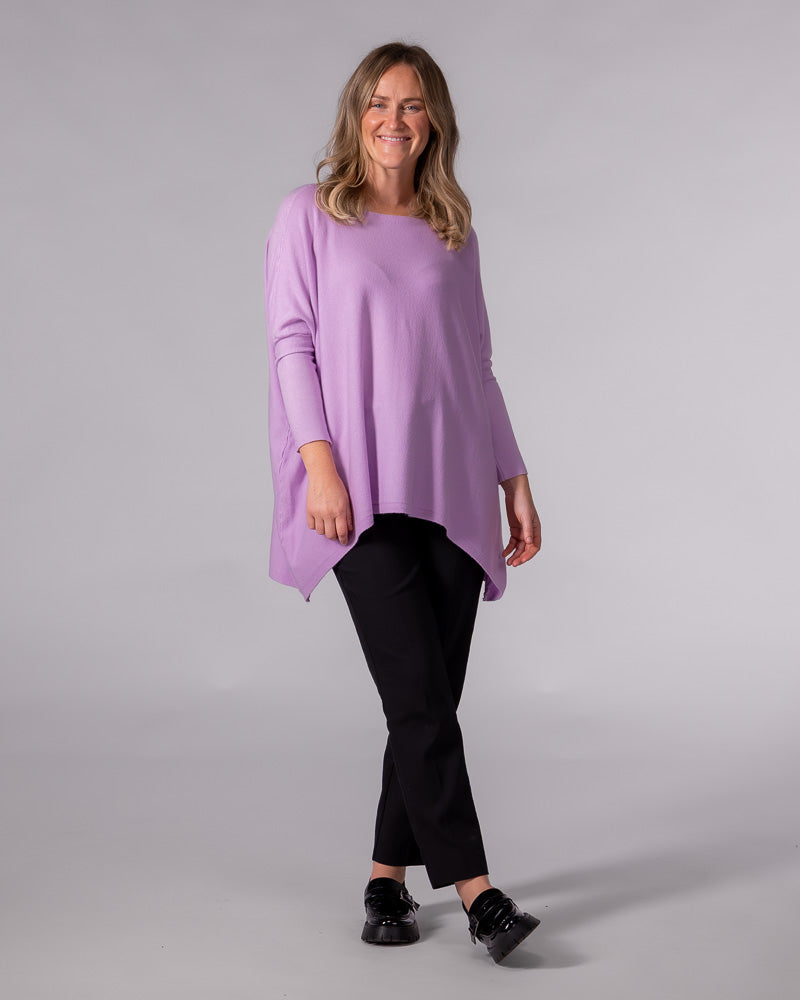 Oversized lilac cotton knit jumper featuring a wide boat neckline, drop shoulders, fitted sleeves and a hi-low hem.