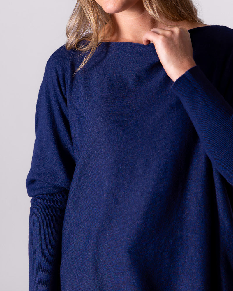 Front detail shot of the relaxed navy jumper capturing the comfortable boat neckline and soft fabric texture.