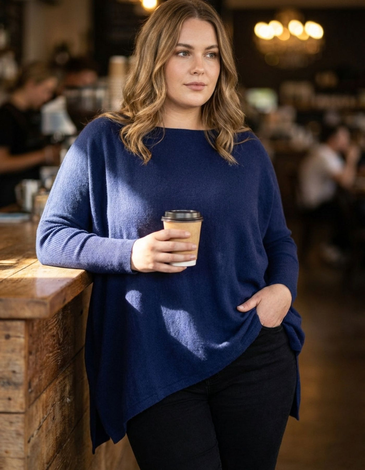 Front half-body view of the relaxed navy knitwear demonstrating the drop shoulders and long ribbed fitted sleeves.
