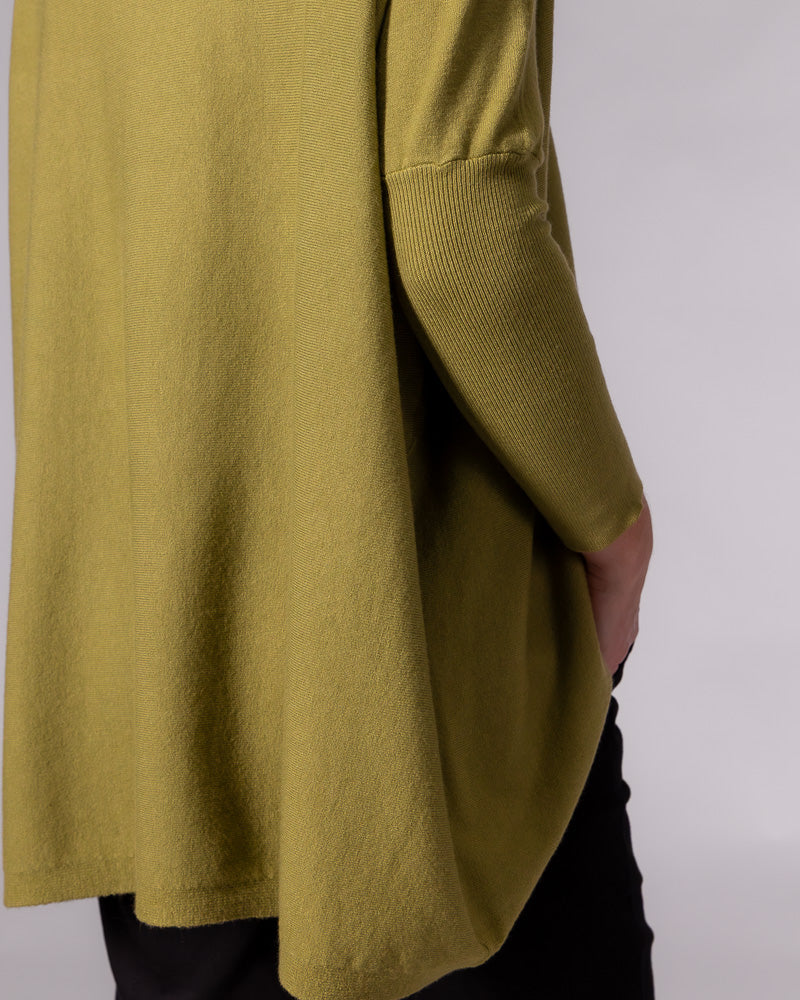Draped back of the oversized olive green cotton jumper, featuring a drop shoulder and fitted ribbed sleeve.