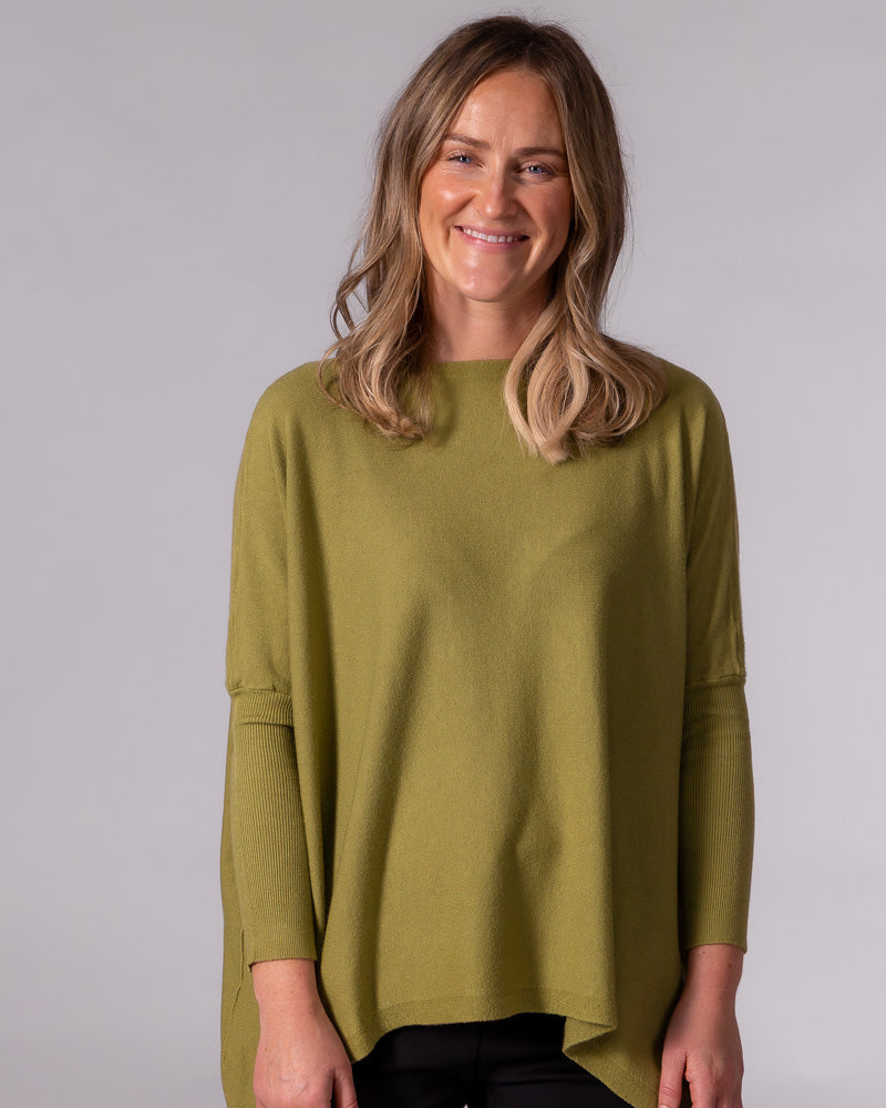 Oversized olive green cotton knit jumper with a boat neckline, drop shoulders, fitted ribbed sleeves, and hi-low hem.