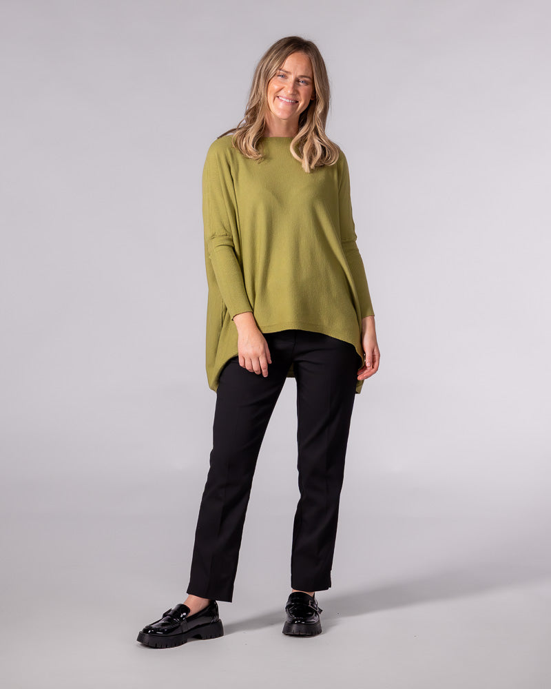 Oversized olive green cotton knit jumper with drop shoulders, fitted sleeves, and a modern hi-low hemline.