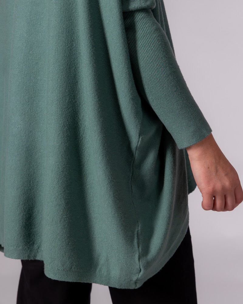 Oversized sage green cotton knit jumper detailing the soft draped body and contrasting fitted drop-shoulder sleeve.
