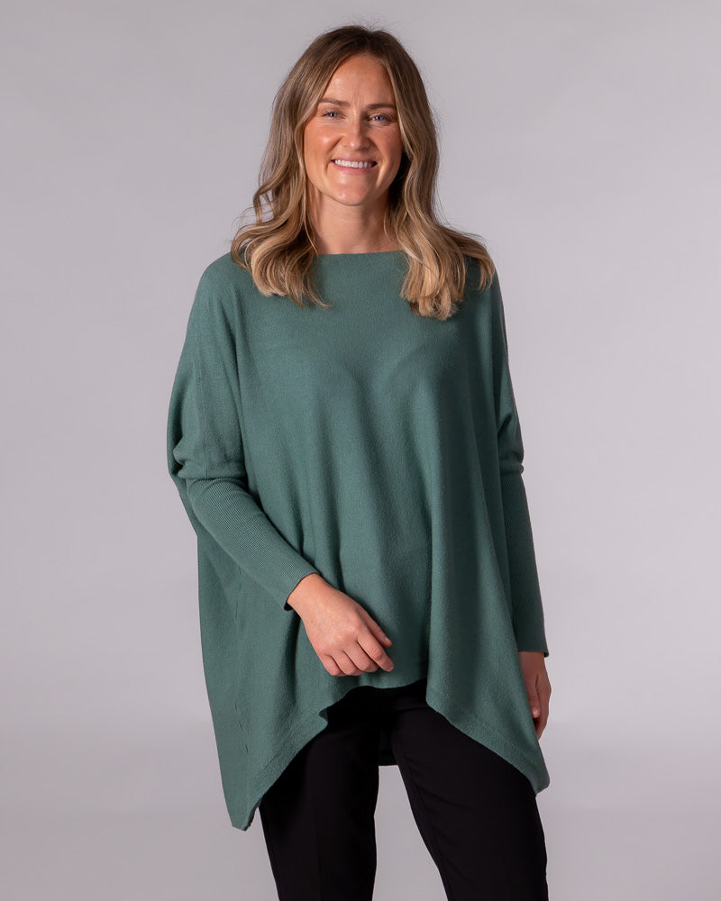 Oversized sage green cotton knit jumper featuring a wide boat neckline, drop shoulders, and long fitted sleeves.