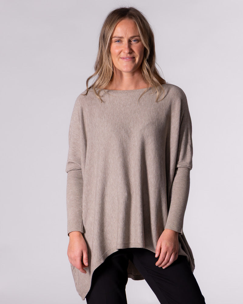 Front facing view of the taupe jumper showcasing the hi-low hemline sitting noticeably higher at the front.