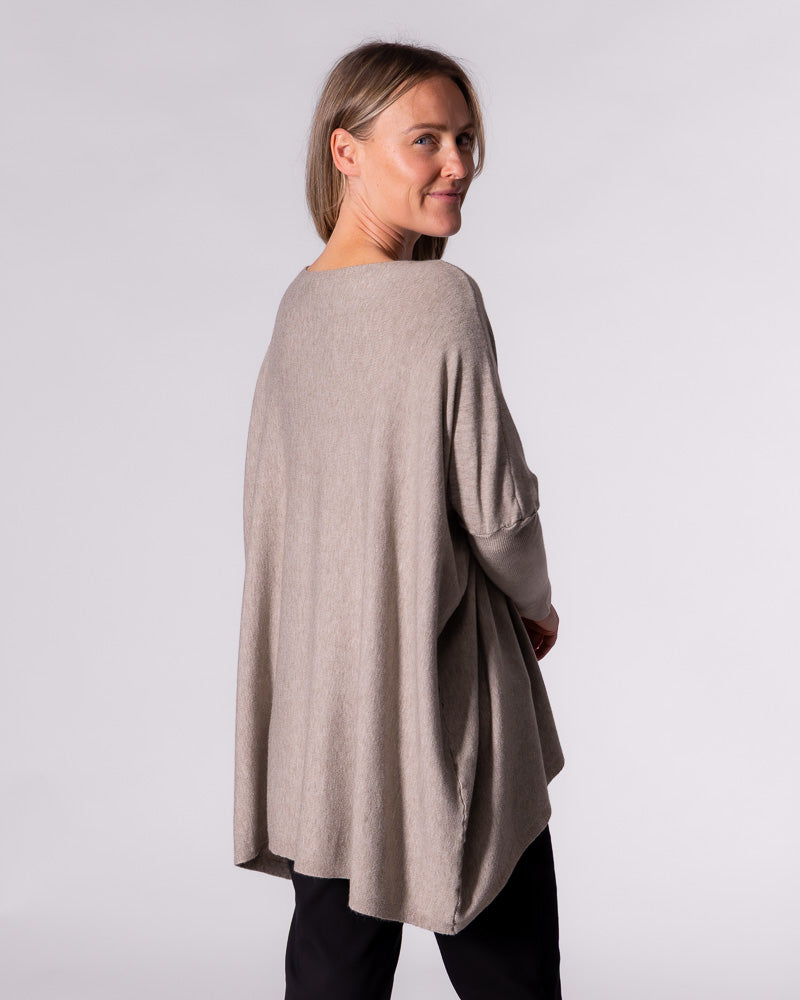 Side profile of the taupe Karma Kameleon knit top demonstrating how the fabric flows and drapes at the back.