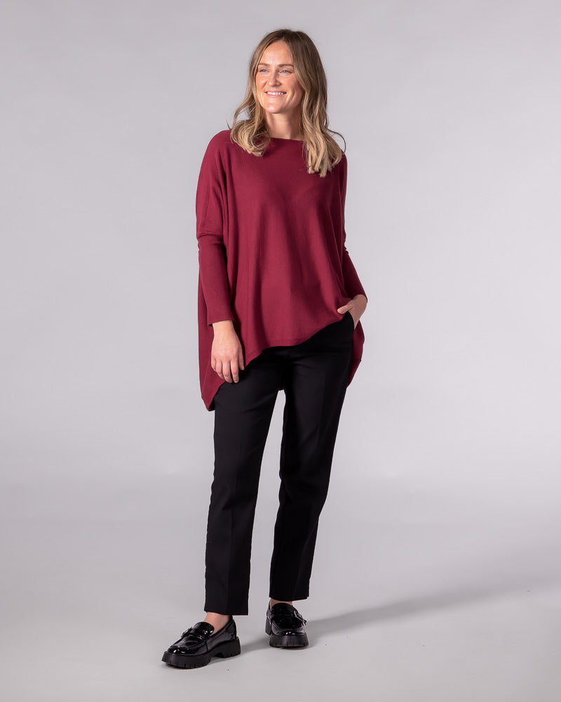 Wine red cotton jumper featuring an oversized draped silhouette, wide boat neckline, drop shoulders and a hi-low hem.