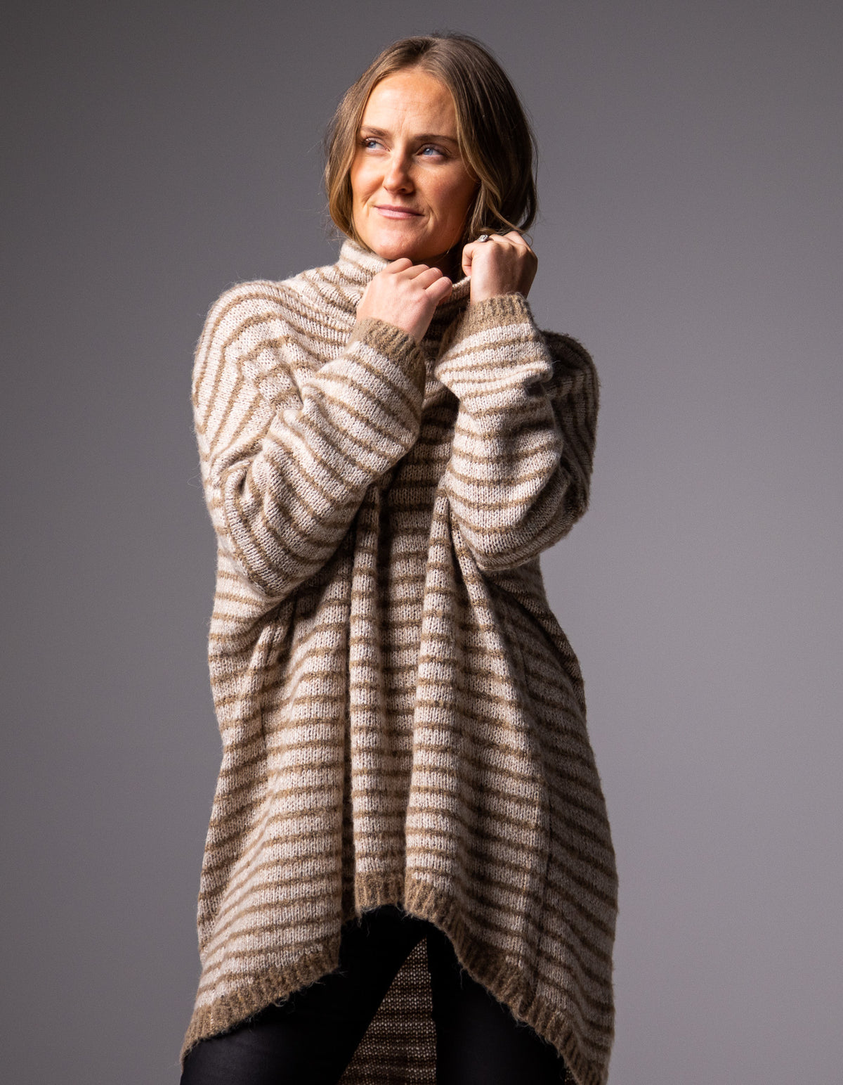 Front half-body shot of the beige and mocha stripe knitwear showcasing the funnel neck design.