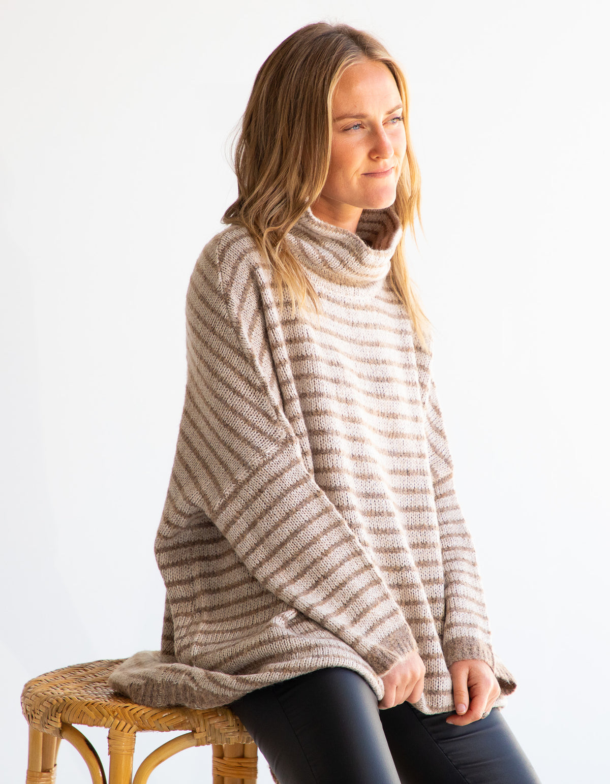 Front half-body shot of the Karma Kameleon beige and mocha stripe knit top highlighting the drop shoulders.